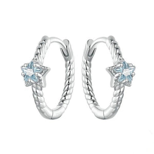 Silver hoop earrings with star-shaped blue gemstones on a white background