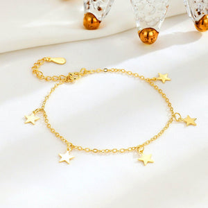 Two sterling silver bracelets with star charms, one with a gold plating, displayed on a white surface.