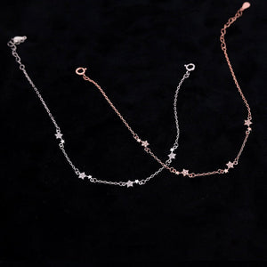 Two gold necklaces with star-shaped pendants on a black background