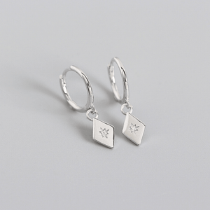 Silver hoop earrings with diamond-shaped pendants on a gray background