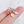 Gold hoop earrings with diamond-shaped charms on a hand against a white background