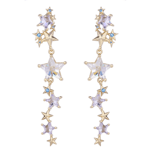 Star-shaped earrings with gold and clear gemstones on a white background