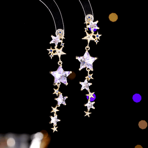 Star-shaped earrings with purple stones on a dark background