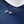 Silver star-shaped earrings on a blue surface with a white dish in the background