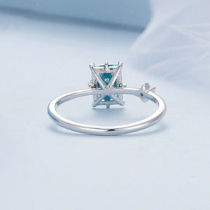 Silver star ring with a green gemstone on a light blue background