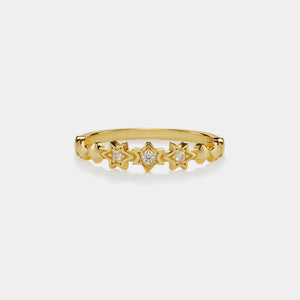 Gold ring with star-shaped diamonds on a light gray background