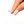 Silver star-shaped ring held by a hand on a white background