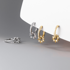 Set of four earrings in gold and silver on a gray background