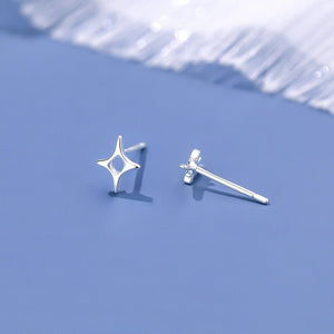 Silver star-shaped earrings on a light blue background