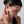 Woman touching her ear with a neutral background