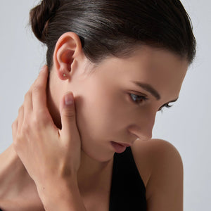 Woman touching her ear with a neutral background