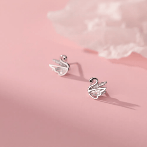 Silver swan earrings on a pink background