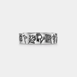 Silver ring with floral designs on a white background