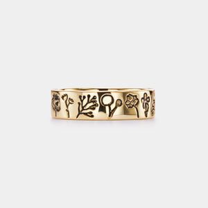 Gold ring with engraved designs on a white background