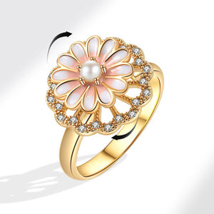 Gold ring with a floral design featuring a pearl and small diamonds on a white background