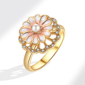 A gold-colored fidget spinner ring with a daisy flower design, featuring pink enamel petals and a pearl center.