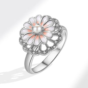 A gold-colored fidget spinner ring with a daisy flower design, featuring pink enamel petals and a pearl center.