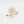 Gold ring with diamond sunburst design on a light gray background