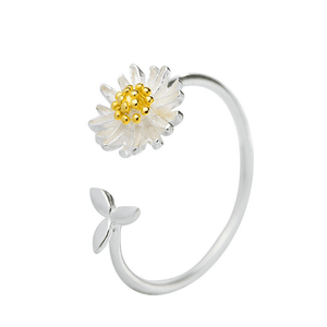 Silver ring with a white flower and gold center on a white background