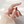 Hand wearing a delicate flower ring on a light background