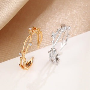 Gold and silver hoop earrings on a beige fabric background