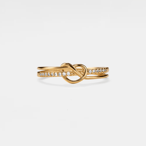 Gold ring with diamond accents on a light gray background