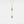 Gold necklace with two circular pendants on a light gray background