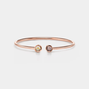 A rose gold-plated sterling silver bangle bracelet with two circular photo projection charms.