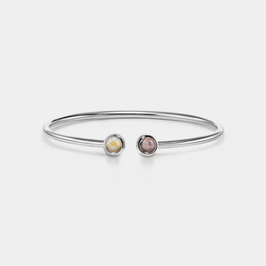 A white gold-plated sterling silver bangle bracelet with two circular photo projection charms.