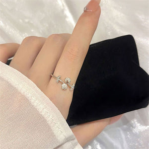 Two tulip flower stacking bypass rings, one plated in gold and the other in silver, with cubic zirconia stones, displayed against a neutral background.