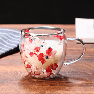 Clear glass mug with red floral design on a wooden surface