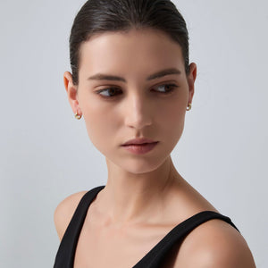Woman wearing a black top against a gray background