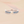 Silver ring with blue gemstones on a soft pink background