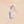 Pair of diamond-studded earrings on a light pink background