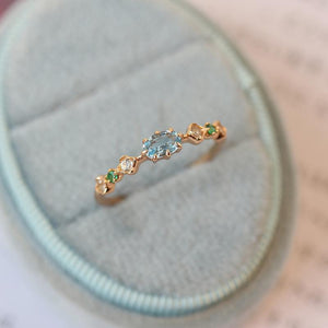 Rose gold ring with gemstones on a soft fabric background