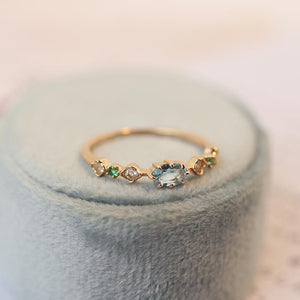 Gold ring with gemstones on a soft fabric background