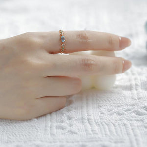 Hand wearing a ring on a textured white surface