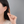 Person wearing gold earrings with a plain background