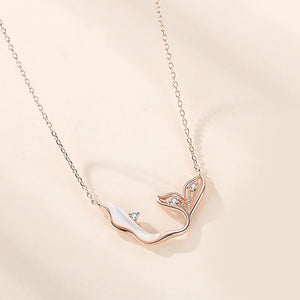 Rose gold necklace with a delicate pendant on a beige background
