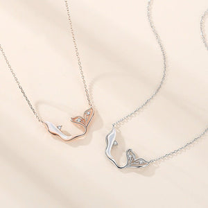 Two silver necklaces with fox designs on a beige background