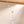 Pearl necklace with rose gold accents on a beige background