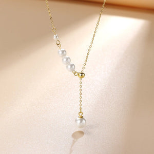 Pearl necklace with gold chain on a beige background