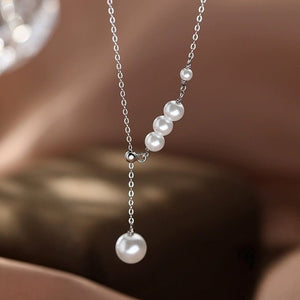 Pearl necklace with silver chain on a blurred background