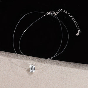 Silver necklace with a pendant on a black and beige gradient background