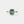 Gold ring with a green gemstone and small diamonds on a light gray background