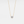 An emerald cut moissanite stone set in a silver and gold necklace with a chain.