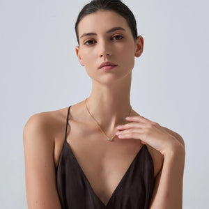 Woman wearing a necklace on a plain background