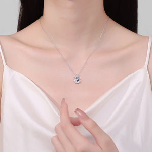 Necklace with a pendant worn by a person, highlighting the jewelry against a neutral background.