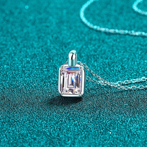 Silver necklace with a rectangular diamond pendant on a teal background