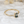 Gold ring with a green gemstone on a marble surface
